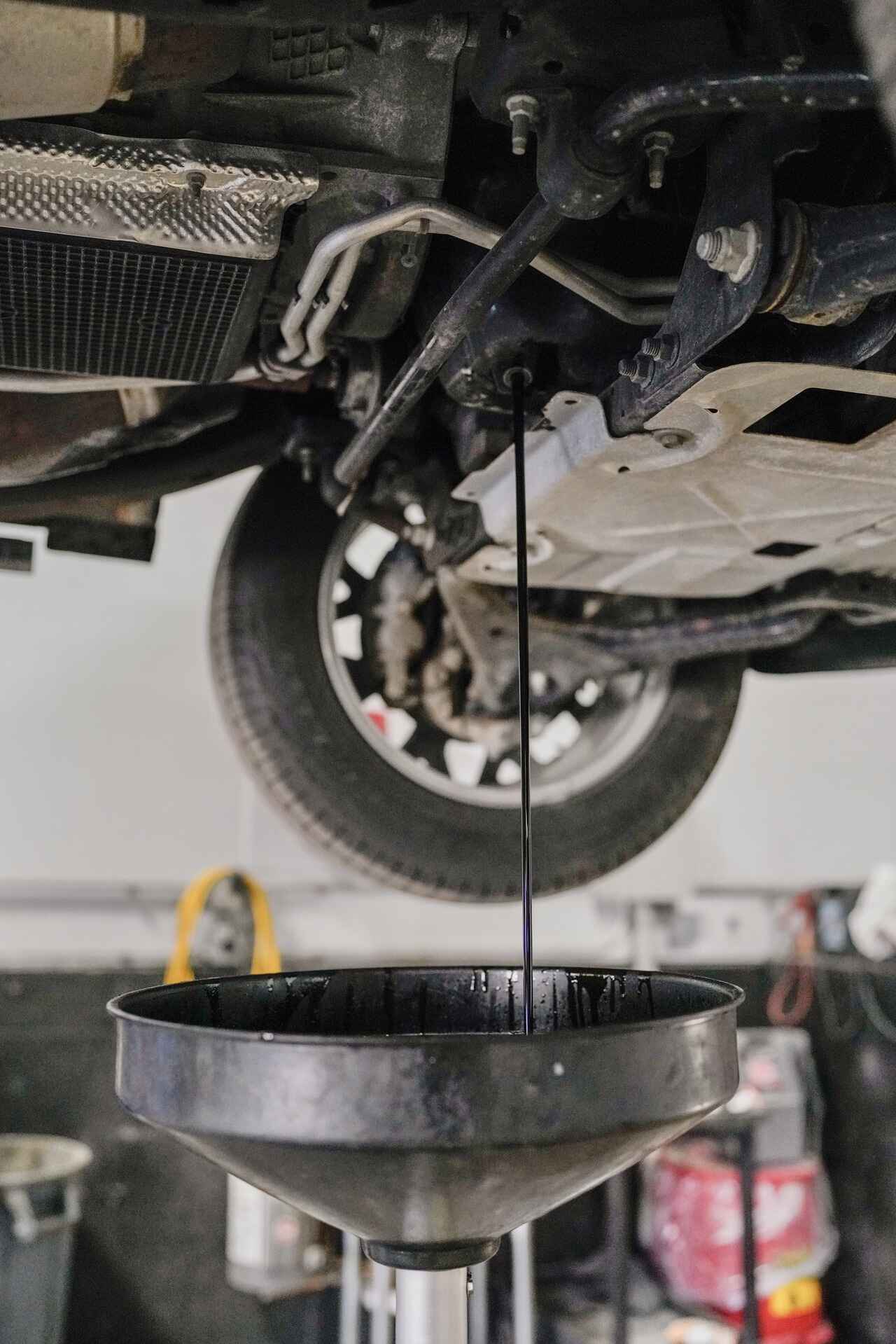 Man holding a diagnostic tool to preform general maintenance on car.